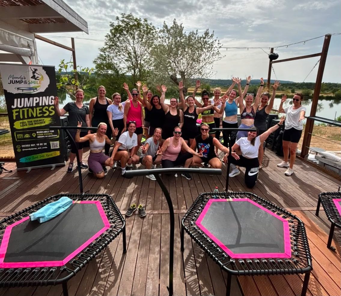 A bellicon® JUMPING class on the lakeside terrace, hands in the air after the session